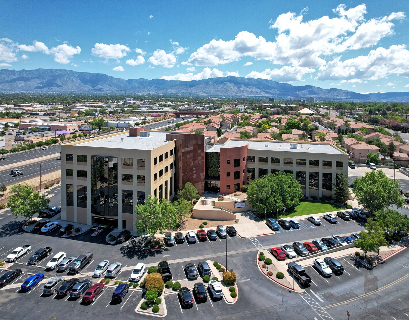 an aerial view of a building with mountains in the background